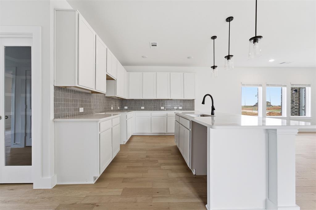 225 Charismatic Road Waxahachie, TX 75165 - Photo 6 of 21 a kitchen with kitchen island sink stove and cabinets