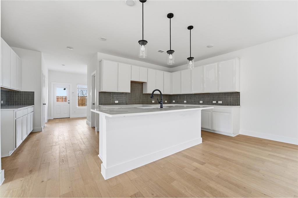 225 Charismatic Road Waxahachie, TX 75165 - Photo 9 of 21 a kitchen with stainless steel appliances granite countertop a sink a stove a refrigerator and white cabinets