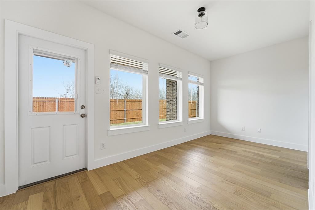 225 Charismatic Road Waxahachie, TX 75165 - Photo 10 of 21 a view of an empty room with wooden floor and a window