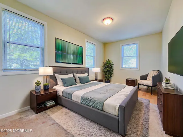 a bedroom with a bed and a flat tv screen on dresser