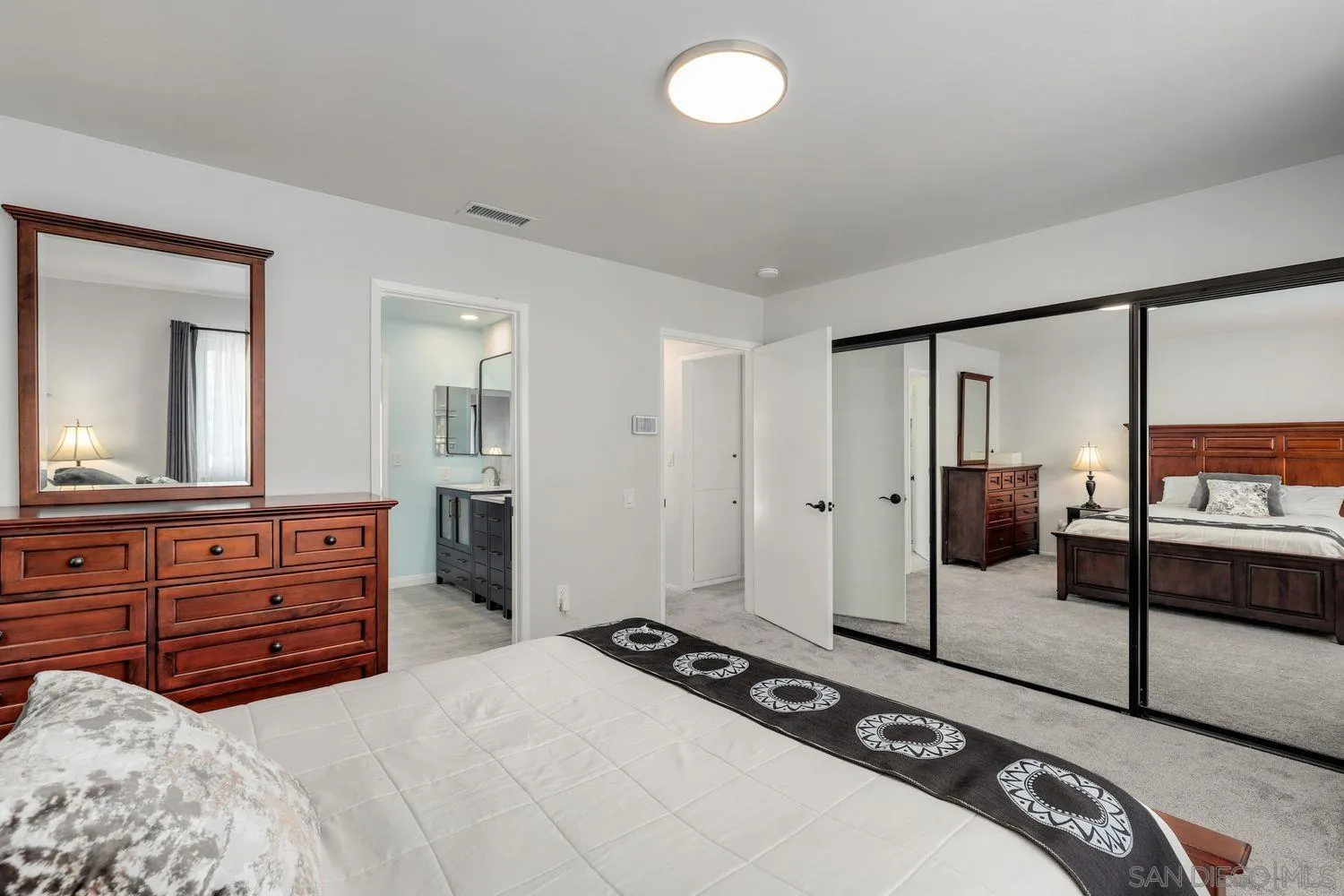 12496 Bodega Road San Diego, CA 92128 - Photo 17 of 44 a bedroom with a bed and a large mirror