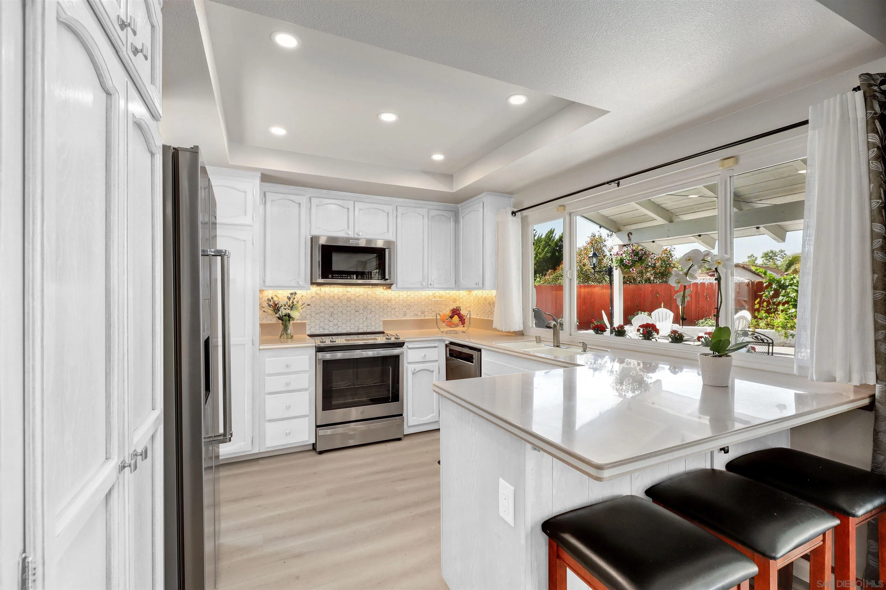 12496 Bodega Road San Diego, CA 92128 - Photo 9 of 44 a open kitchen with white cabinets and stainless steel appliances