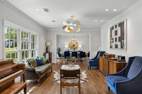 a living room with furniture chandelier and a large window
