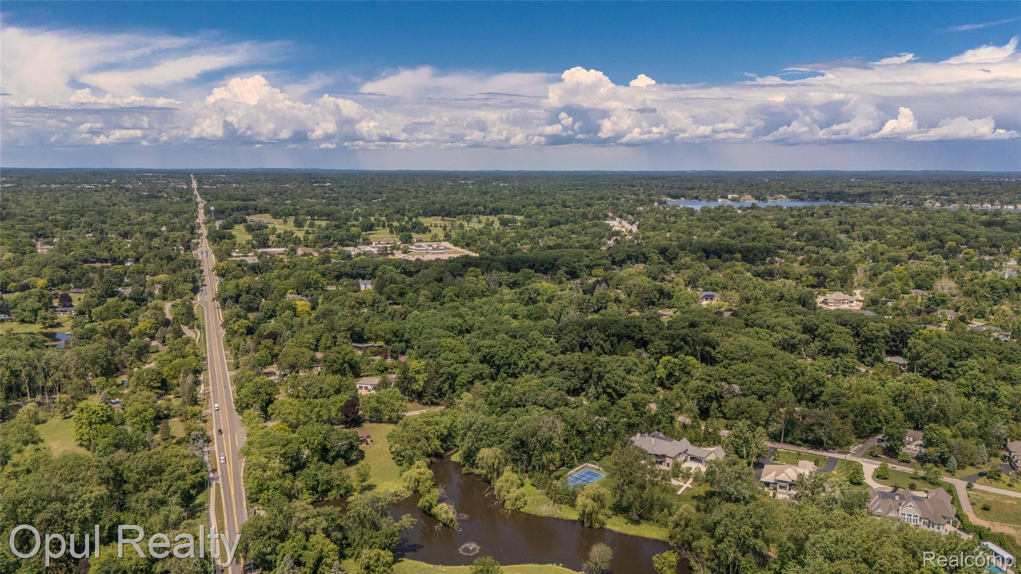6455 Norham Road Bloomfield Hills, MI 48301 - Photo 77 of 93 Expansive aerial view showcasing a verdant landscape with extensive tree canopy and multiple bodies of water