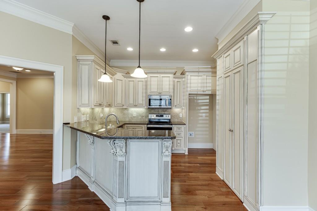 2390 Muskogee Lane Braselton, GA 30517 - Photo 11 of 40 a kitchen with stainless steel appliances granite countertop a sink a stove and a wooden floor