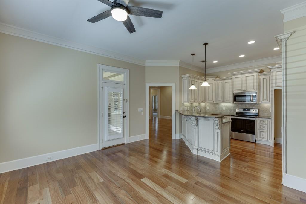 2390 Muskogee Lane Braselton, GA 30517 - Photo 14 of 40 a kitchen with stainless steel appliances kitchen island granite countertop a refrigerator a oven a sink and white cabinets with wooden floor