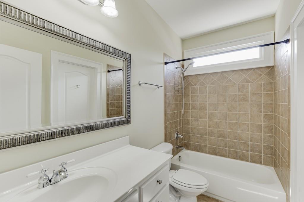 2390 Muskogee Lane Braselton, GA 30517 - Photo 33 of 40 a bathroom with a bathtub shower sink vanity and toilet
