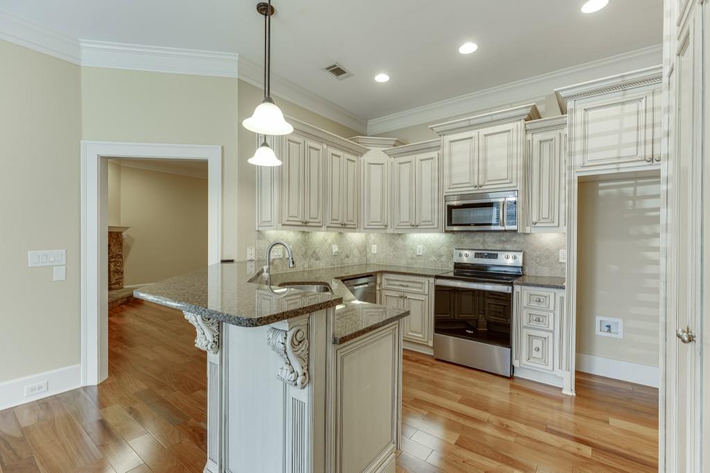 2390 Muskogee Lane Braselton, GA 30517 - Photo 10 of 40 a kitchen with stainless steel appliances granite countertop a sink a stove and a refrigerator