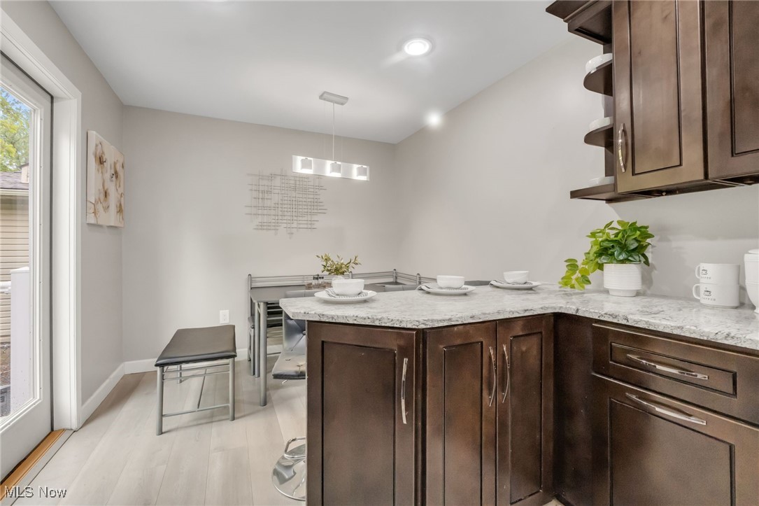 2524 Claver Road Cleveland, OH 44118 - Photo 20 of 50 Kitchen featuring dark brown cabinetry, a peninsula, light wood-style flooring, light stone counters, and recessed lighting
