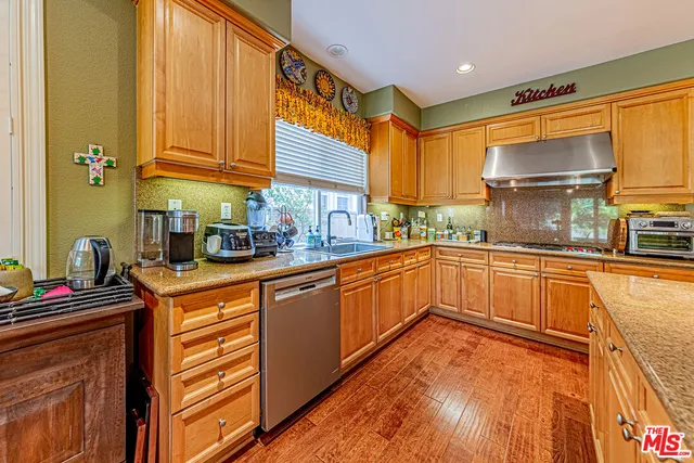 a kitchen with stainless steel appliances granite countertop a sink and cabinets