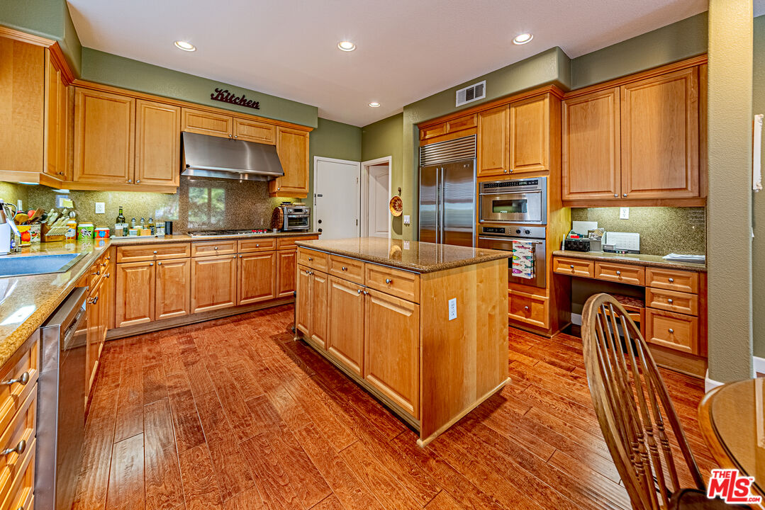 23208 Maple Avenue Torrance, CA 90505 - Photo 17 of 62 a kitchen with stainless steel appliances granite countertop a stove top oven a sink a dining table and chairs