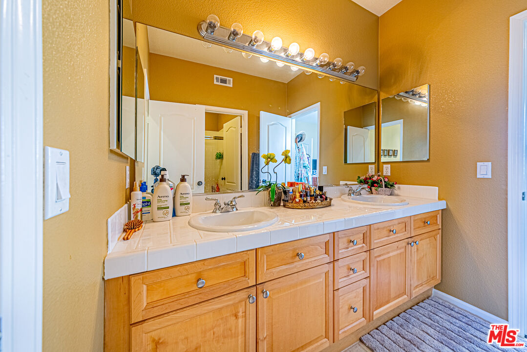 23208 Maple Avenue Torrance, CA 90505 - Photo 29 of 62 a bathroom with a double vanity sink and a mirror