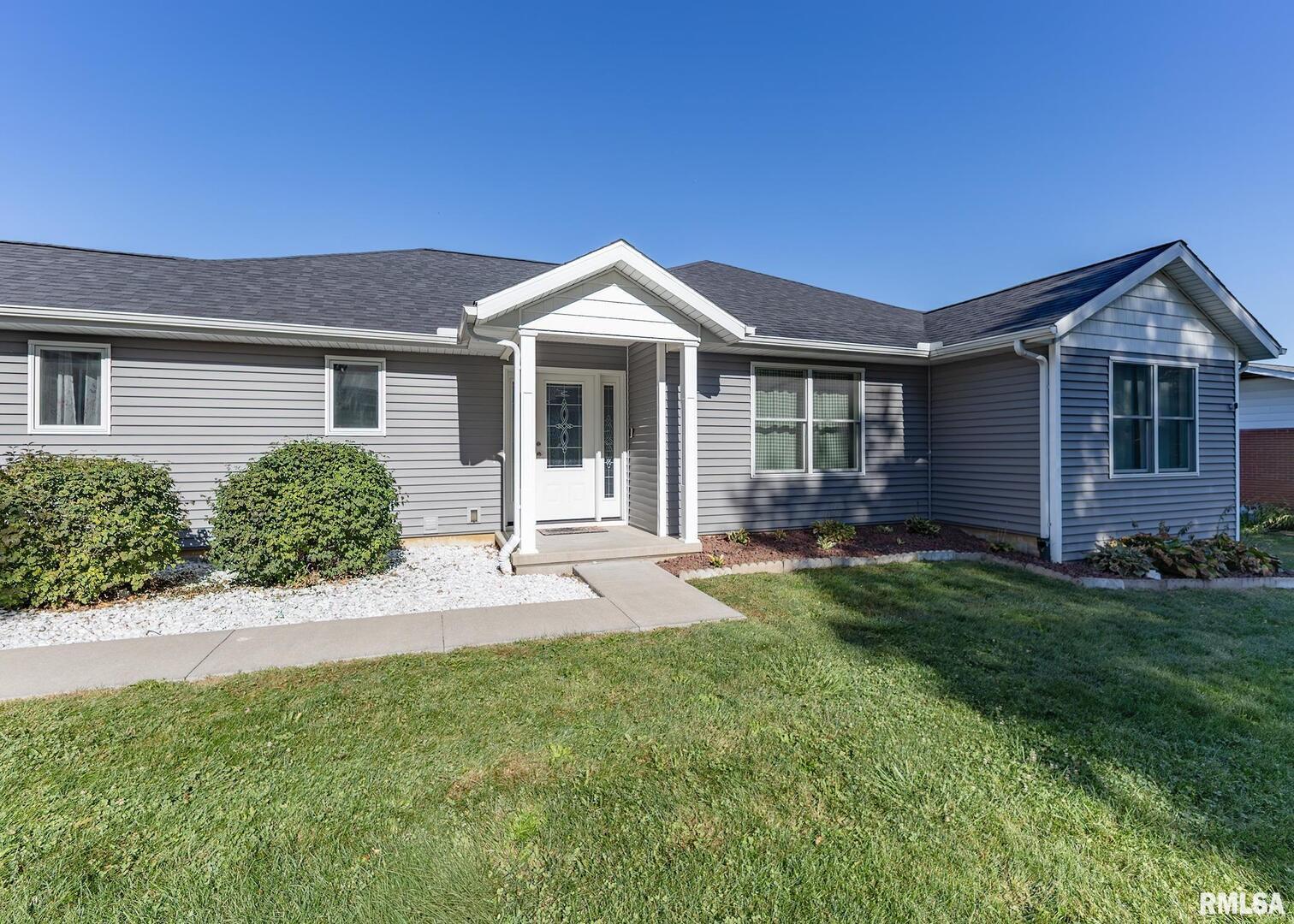 a front view of a house with yard and green space