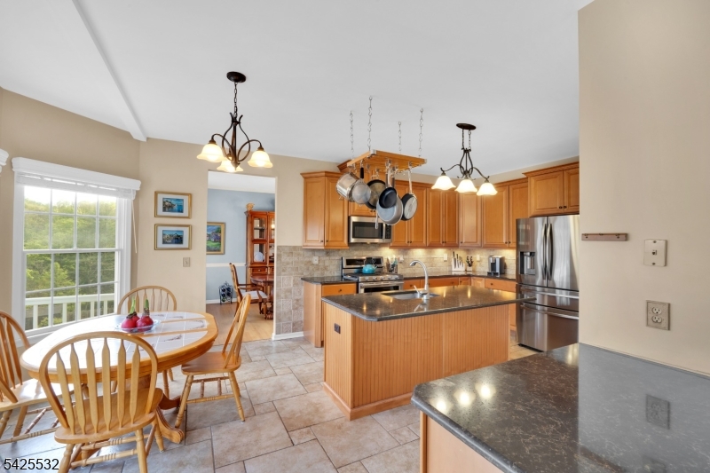 6 Ridge Road Frenchtown, NJ 08825 - Photo 13 of 33 a kitchen with stainless steel appliances granite countertop a stove top oven a refrigerator a dining table and chairs with wooden floor