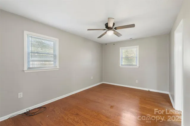 a view of a big room with wooden floor and windows in a room