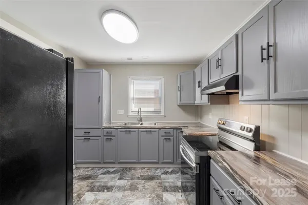 a kitchen with stainless steel appliances granite countertop a sink a stove and a refrigerator