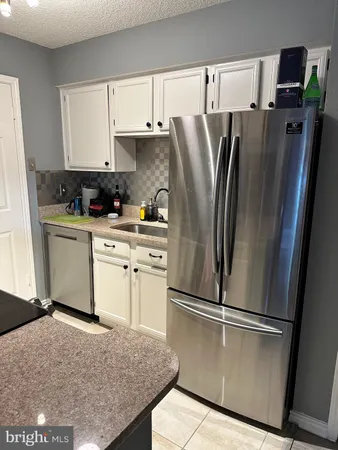 a kitchen with stainless steel appliances granite countertop a refrigerator a stove and a sink