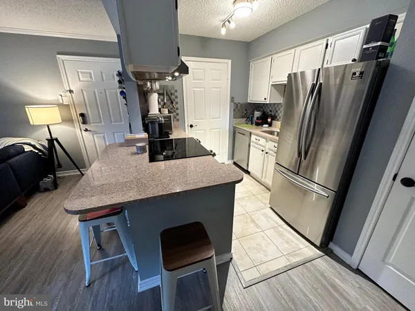 a kitchen with kitchen island a counter top space wooden floor and stainless steel appliances