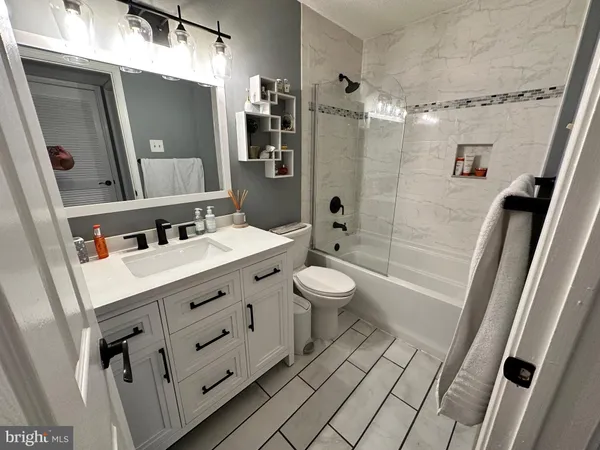 a bathroom with a sink a toilet a mirror and shower
