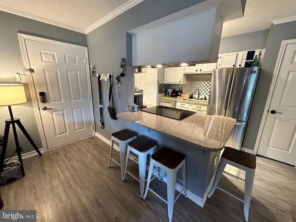 a kitchen with a table chairs refrigerator and a stove