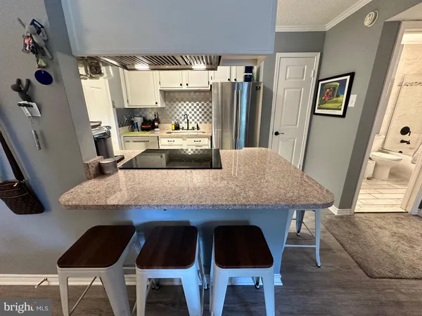 a kitchen with granite countertop a table chairs stove and cabinets