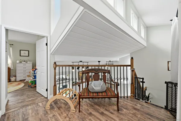 a view of a hallway with wooden floor and stairs