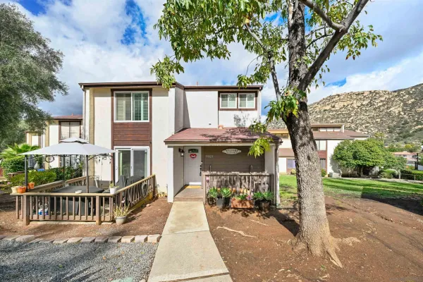 a front view of a house with a tree