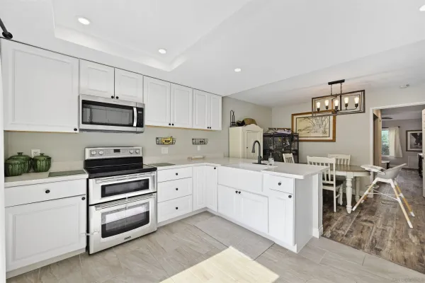 a kitchen with cabinets stainless steel appliances and wooden floor