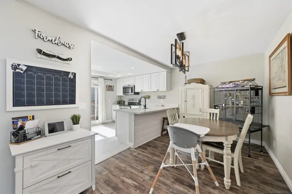 a kitchen with a dining table chairs and white cabinets