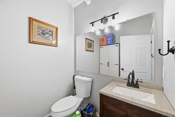 a bathroom with a sink vanity mirror and toilet