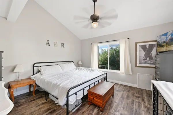 a bedroom with a bed chandelier and a window