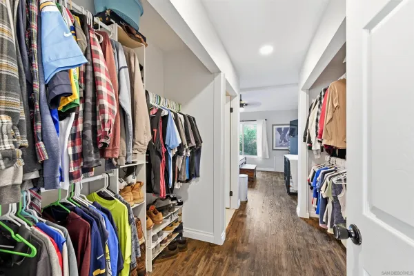 a view of walk in closet with clothes and shoes