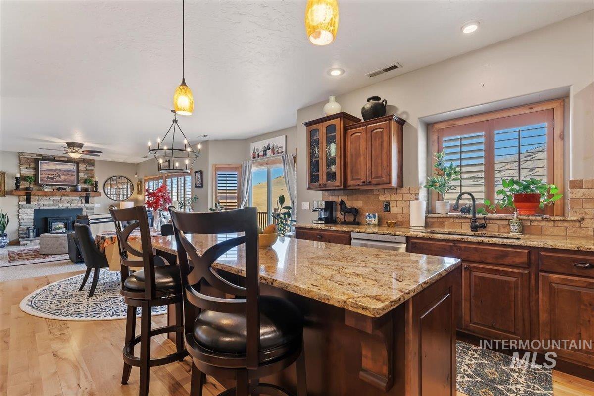 11660 Timber Butte Road Sweet, ID 83670 - Photo 14 of 49 Gourmet kitchen featuring a granite-topped island, rich wood cabinetry, stainless steel appliances, and a tile backsplash