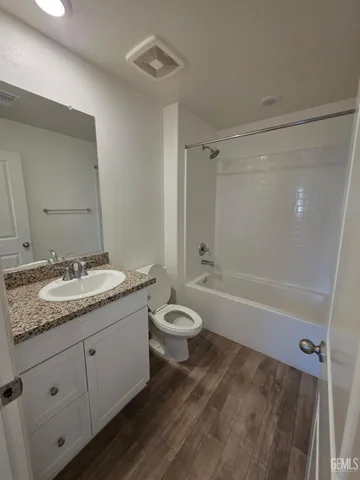 a bathroom with a granite countertop sink toilet a large mirror a bathtub and shower