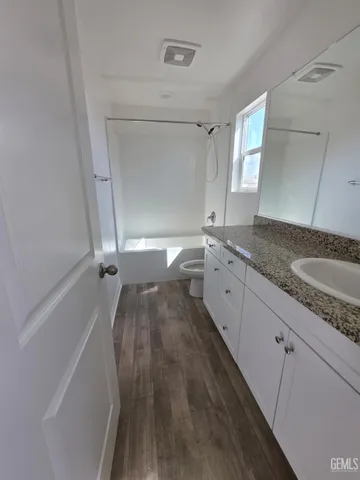 a bathroom with a granite countertop sink toilet and shower