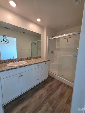a bathroom with a granite countertop sink mirror and shower
