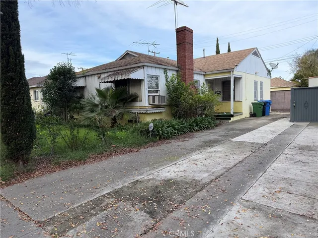 a front view of a house with a yard and potted plants