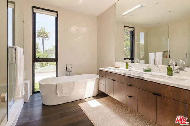 a bedroom with a bed and large windows