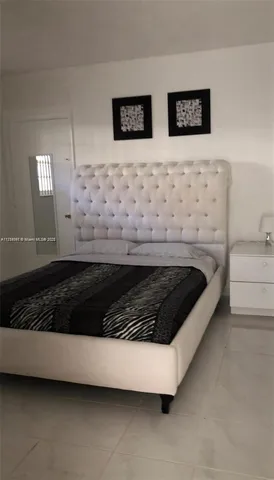 a bed sitting in a bedroom next to a window