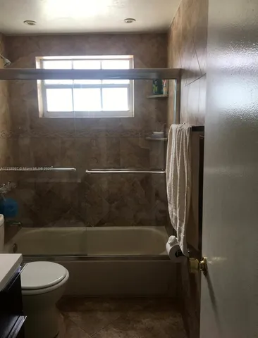 a bathroom with a granite countertop toilet and a shower