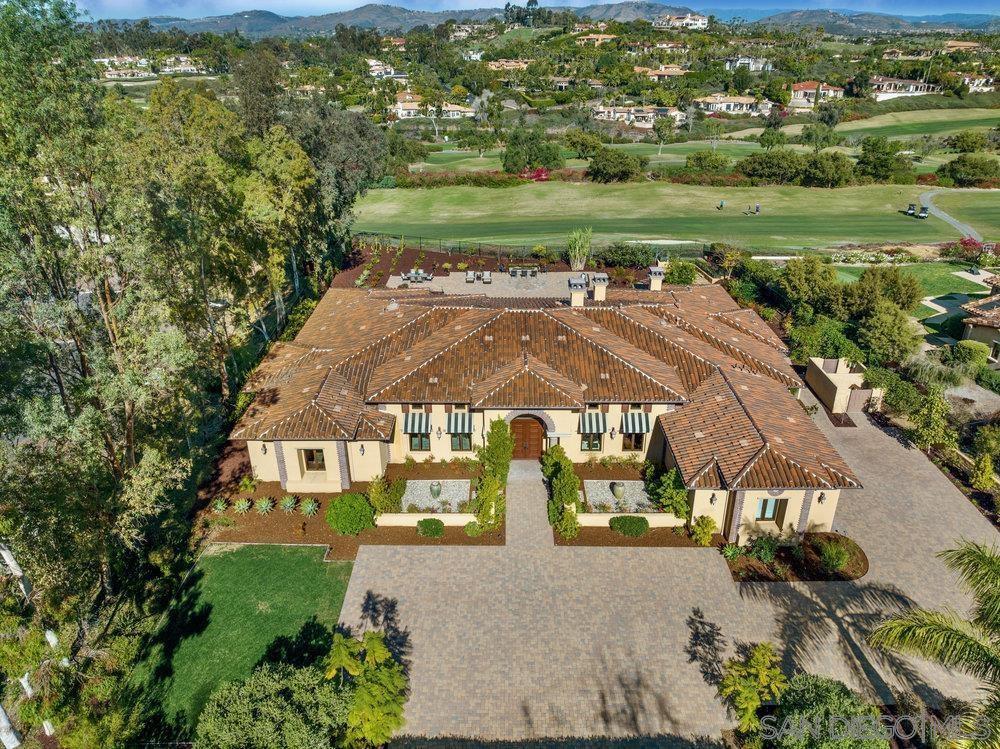 an aerial view of residential houses with outdoor space and trees