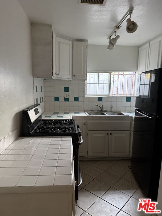 13173 Judd Street Pacoima, CA 91331 - Photo 4 of 9 a kitchen with a sink a stove cabinets and a window