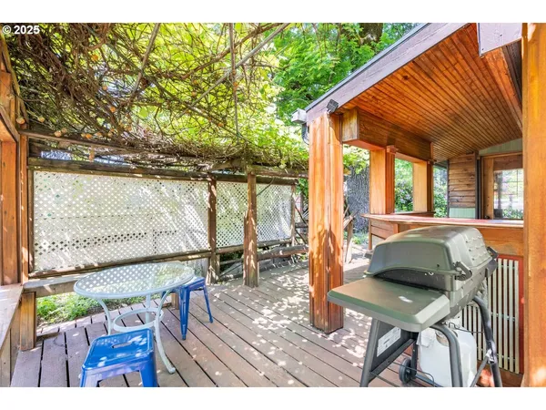 a view of a patio with table and chairs with wooden floor and fence