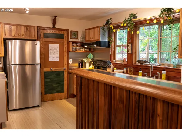 a kitchen view with wooden floor and outdoor space