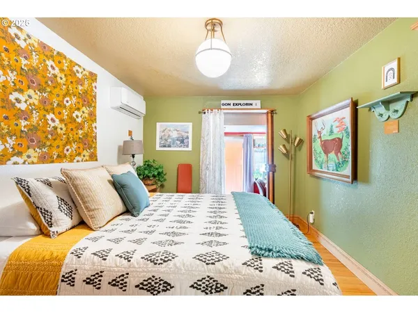 a bedroom with a bed and painting on the wall