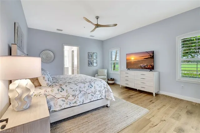 a bedroom with a large bed a flat screen tv and a chandelier