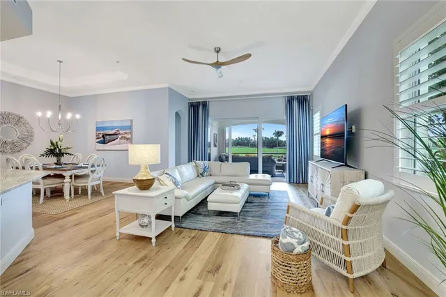 a living room with furniture a flat screen tv and a large window