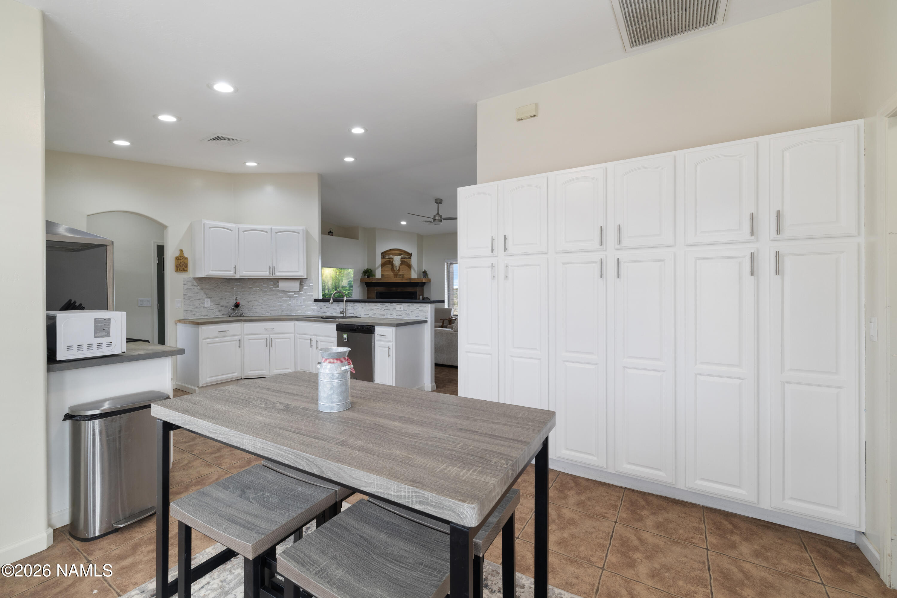 3097 Whitetail Loop Williams, AZ 86046 - Photo 11 of 46 a kitchen with kitchen island a wooden floor and white cabinets