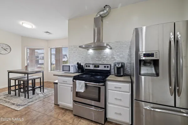 a kitchen with cabinets stainless steel appliances and a dining table