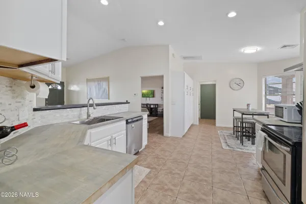 a kitchen with kitchen island a wooden floor and white cabinets